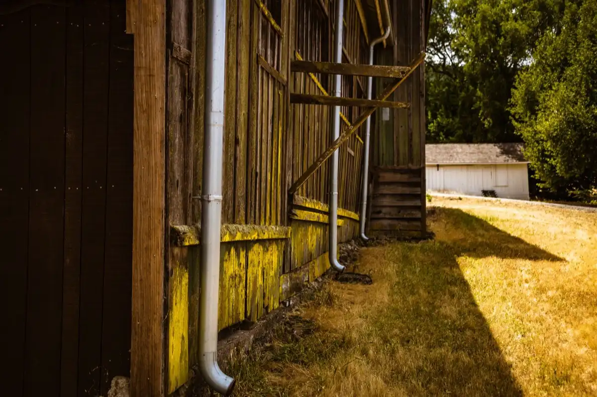 Roof edge, fascia and downspout on a house in Pomona, CA, where drip edge carries runoff into the gutter